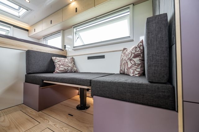 Iveco Daily 4x4 Zusatzbett in Fahrzeug für Langzeitreisende. Tisch ist Höhenverstellbar und kann zum Bett oder Lounge umgebaut werden